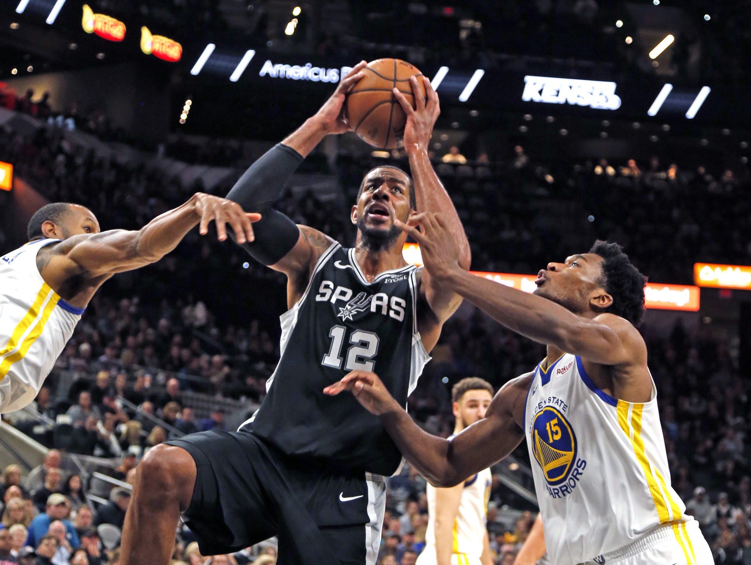 SAN ANTONIO, TX - NOVEMBER 18: LaMarcus Aldridge #12 of the San Antonio Spurs drives for two between Andre Iguodala #9 of the Golden State Warriors and Damian Jones #15 of the Golden State Warriors at AT&T Center on November 18 , 2018 in San Antonio, Texas. NOTE TO USER: User expressly acknowledges and agrees that , by downloading and or using this photograph, User is consenting to the terms and conditions of the Getty Images License Agreement. (Photo by Ronald Cortes/Getty Images)
