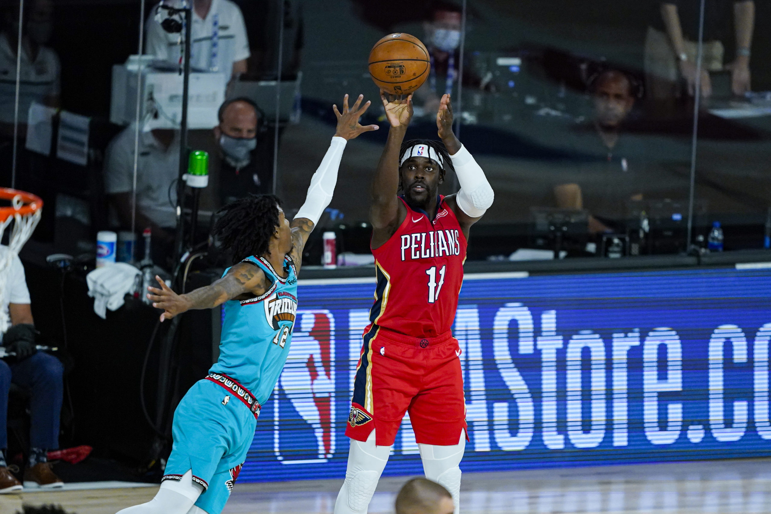 LAKE BUENA VISTA, FLORIDA - AUGUST 03: Jrue Holiday #11 of the New Orleans Pelicans shoots over Ja Morant #12 of the Memphis Grizzlies during the first half of an NBA basketball game at HP Field House at ESPN Wide World Of Sports Complex on August 3, 2020 in Lake Buena Vista, Florida. NOTE TO USER: User expressly acknowledges and agrees that, by downloading and or using this photograph, User is consenting to the terms and conditions of the Getty Images License Agreement. (Photo by Ashley Landis - Pool/Getty Images)
