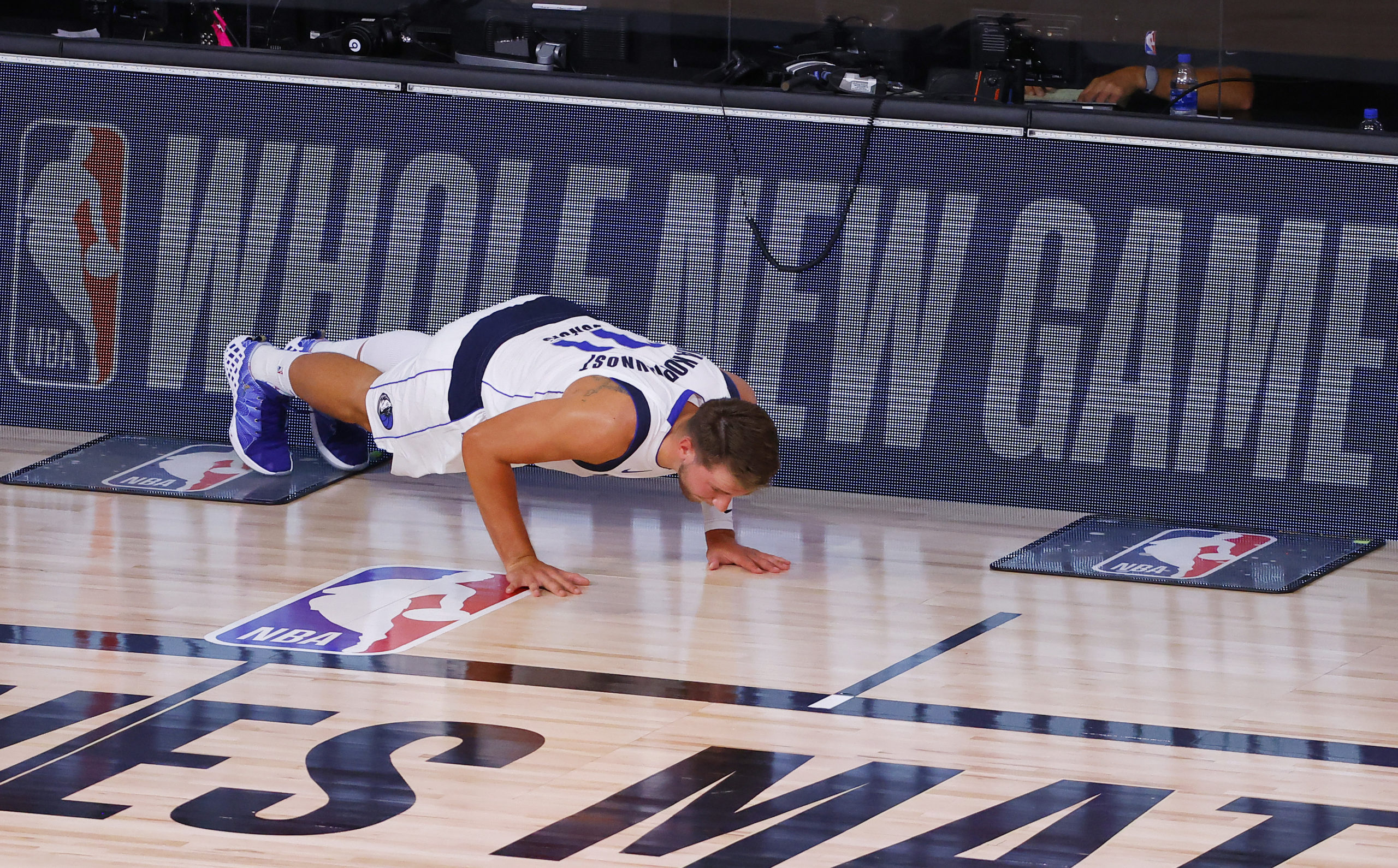 LAKE BUENA VISTA, FLORIDA - AUGUST 08: Luka Doncic #77 of the Dallas Mavericks does some push ups before going into the game against the Milwaukee Bucks at The Arena at ESPN Wide World Of Sports Complex on August 08, 2020 in Lake Buena Vista, Florida. NOTE TO USER: User expressly acknowledges and agrees that, by downloading and or using this photograph, User is consenting to the terms and conditions of the Getty Images License Agreement. (Photo by Kevin C. Cox/Getty Images)