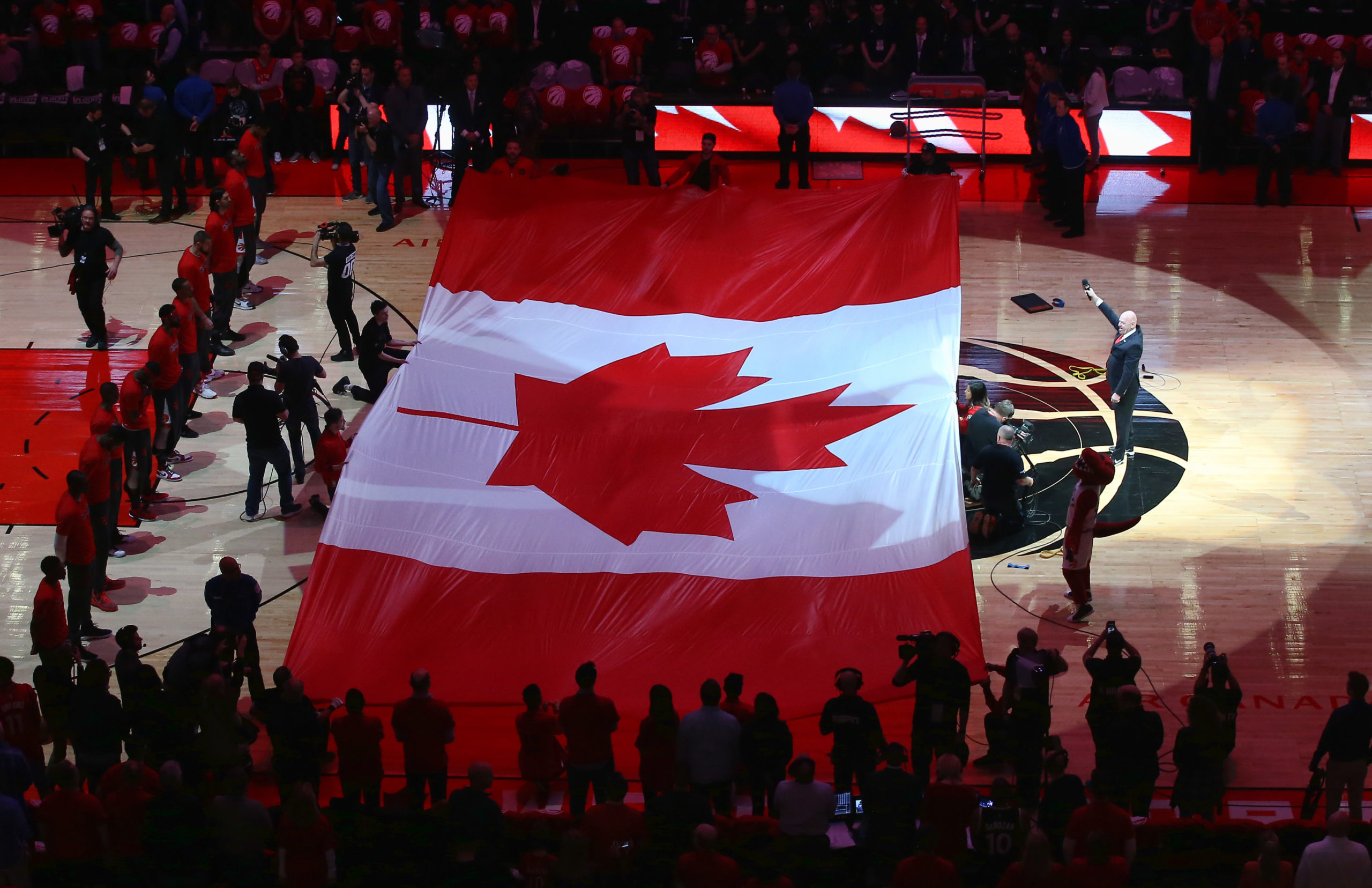 TORONTO, CANADA - APRIL 16: A large Canadian flag is unfurled during the singing of O Canada before the start of the Toronto Raptors game against the Indiana Pacers in Game One of the Eastern Conference Quarterfinals during the 2016 NBA Playoffs on April 16, 2016 at the Air Canada Centre in Toronto, Ontario, Canada. NOTE TO USER: User expressly acknowledges and agrees that, by downloading and or using this photograph, User is consenting to the terms and conditions of the Getty Images License Agreement. (Photo by Tom Szczerbowski/Getty Images)