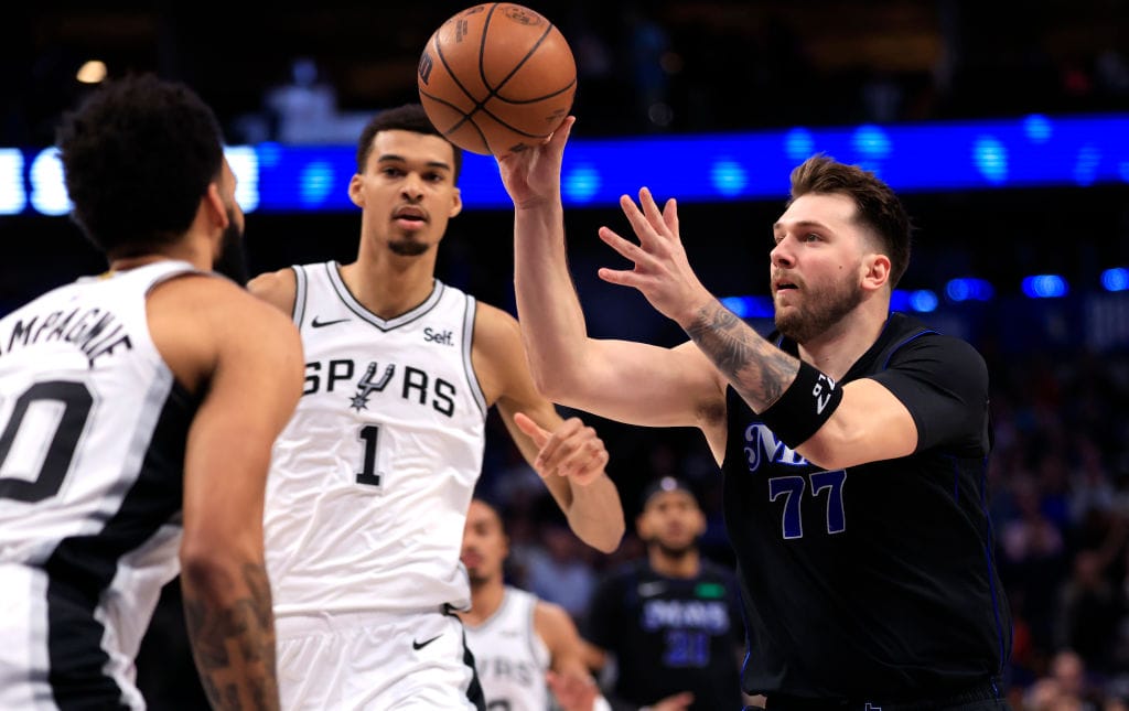 Luka Doncic lanza un pase vigilado por Victor Wembanyama durante un Mvericks vs. Spurs