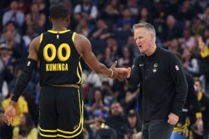 Steve Kerr felicita a Jonathan Kuminga durante un partido