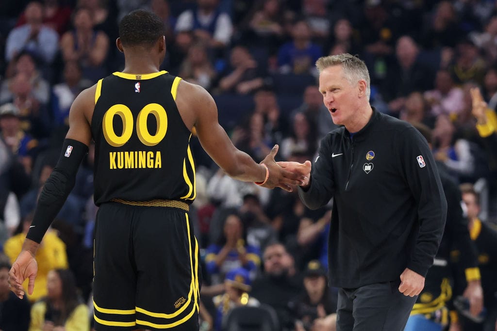 Steve Kerr felicita a Jonathan Kuminga durante un partido