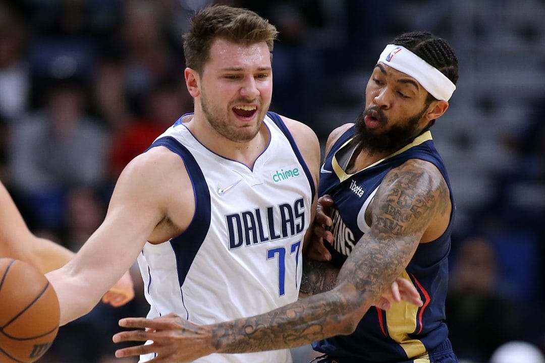 Luka Doncic y Brandon Ingram luchan por un balón