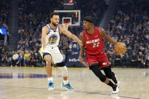 Jimmy Butler trata de superar a Stephen Curry en un partido ante los Warriors