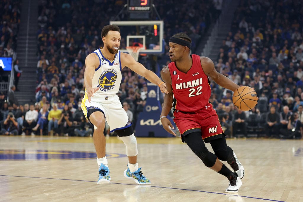 Jimmy Butler trata de superar a Stephen Curry en un partido ante los Warriors