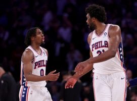 Tyrese Maxey y Joel Embiid discuten durante un partido