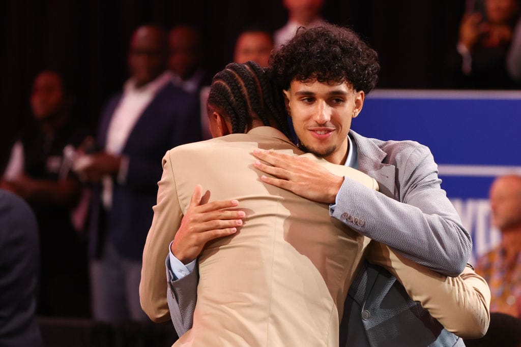 Zaccharie Risacher y Alex Sarr se abrazan durante la noche del Draft de 2024
