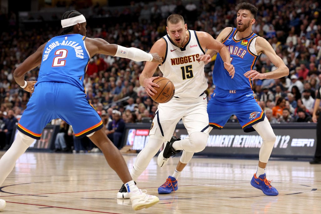 Nikola Jokic se intenta zafar de Chet Holmgren y Shai Gilgeous-Alexander durante un Nuggets vs. Thunder