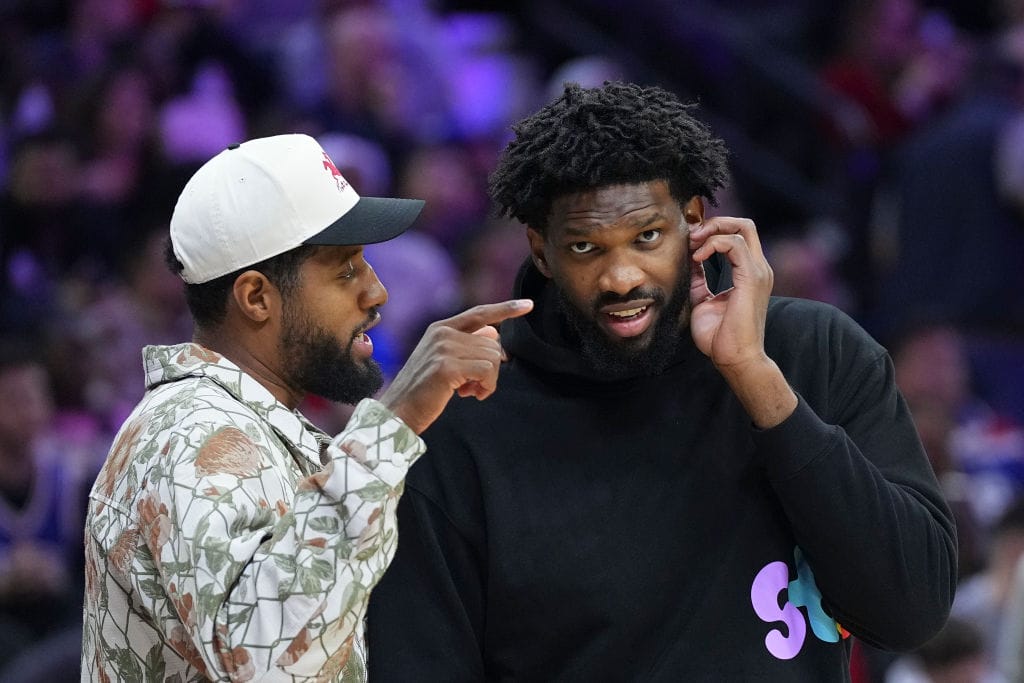 Paul George y Joel Embiid hablan en el banquillo