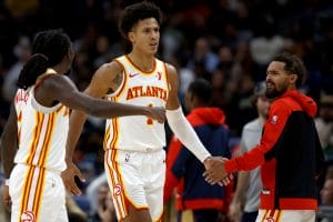 Jalen Johnson choca su mano con Trae Young