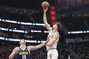 Alperen Sengün trata de anotar por encima de Nikola Jokic