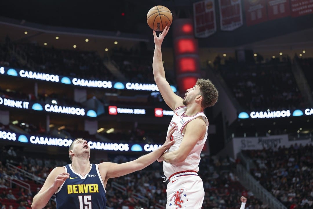 Alperen Sengün trata de anotar por encima de Nikola Jokic