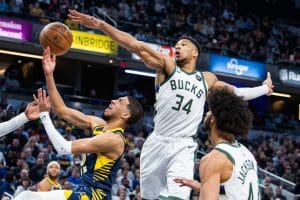 Giannis Antetokounmpo trata de taponar una bandeja de Tyrese Haliburton