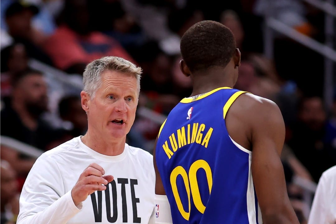 Steve Kerr le da indicaciones a Jonathan Kuminga desde la banda.