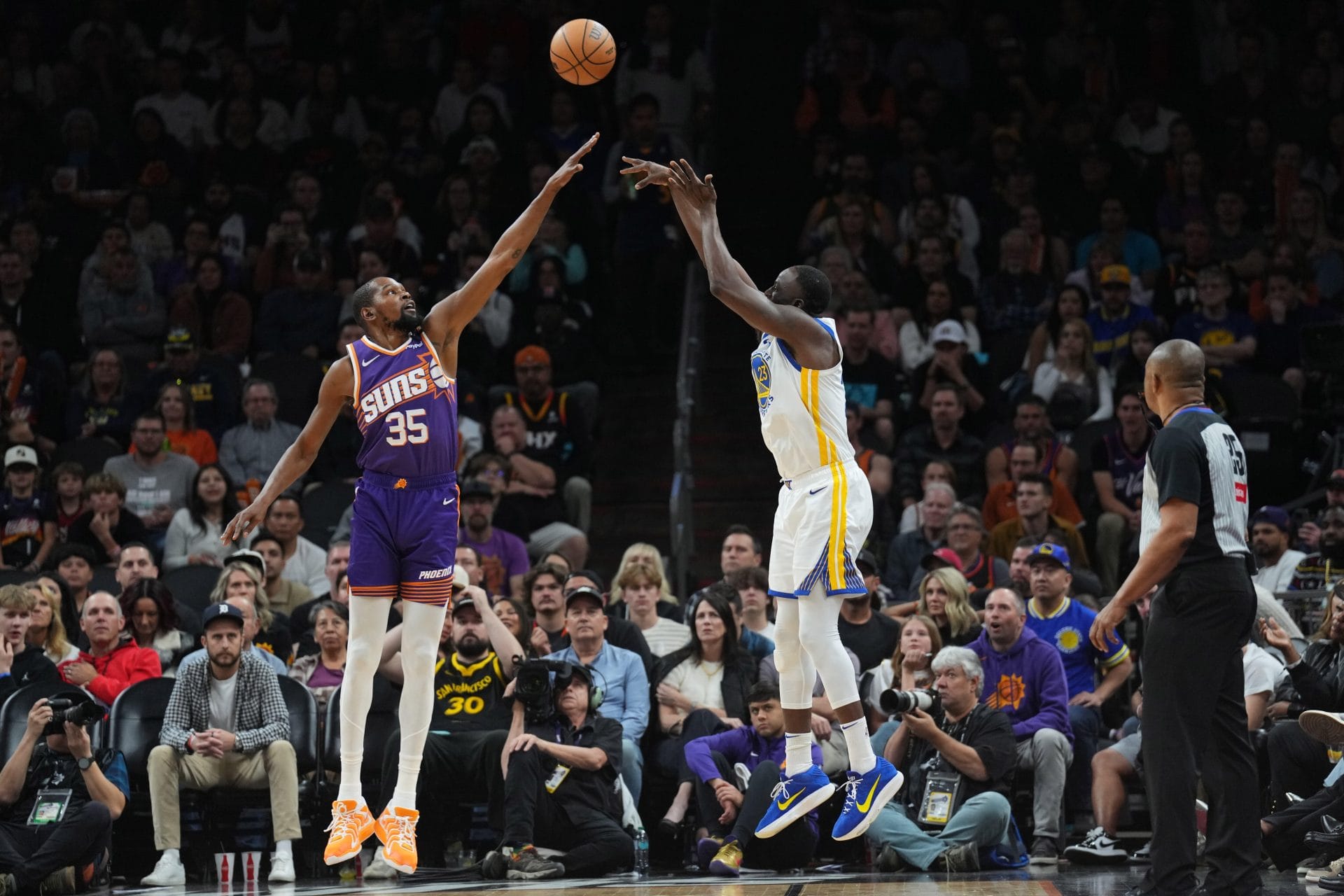 Partido entre Warriors y Suns, con Durant puntenando un tiro de Draymond Green