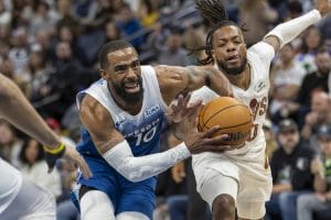Darius Garland trata de arrebatarle el balón a Mike Conley