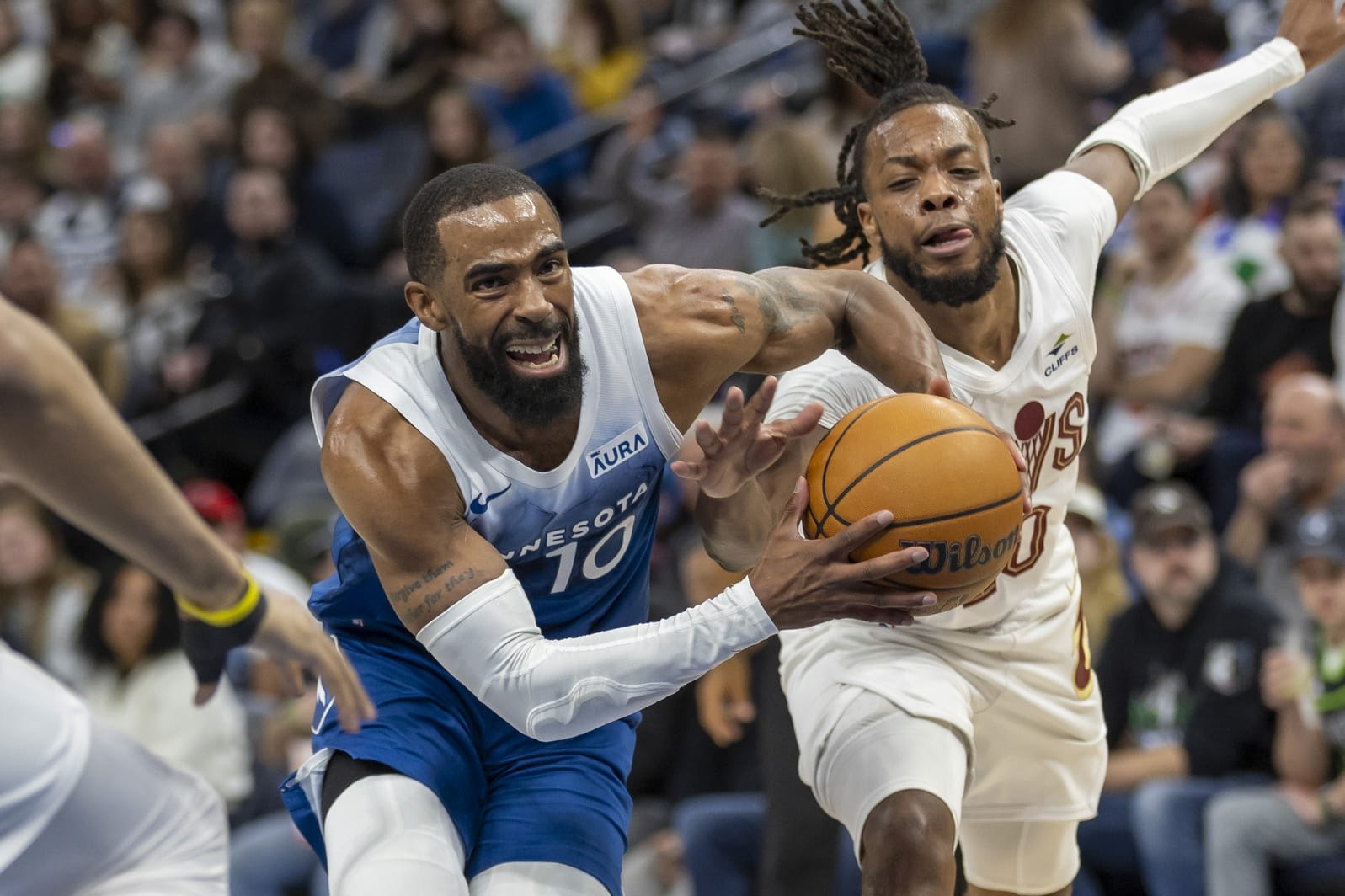 Darius Garland trata de arrebatarle el balón a Mike Conley