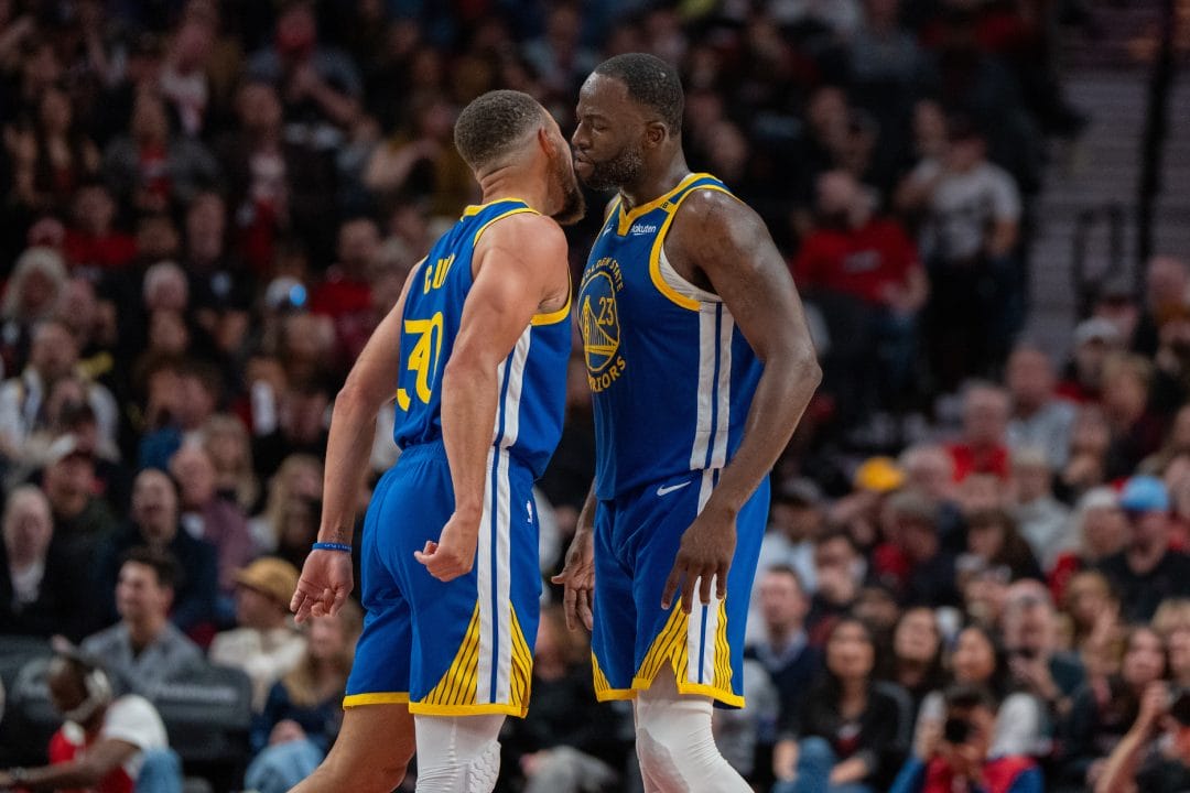 Stephen Curry y Draymond Green celebran una acción.