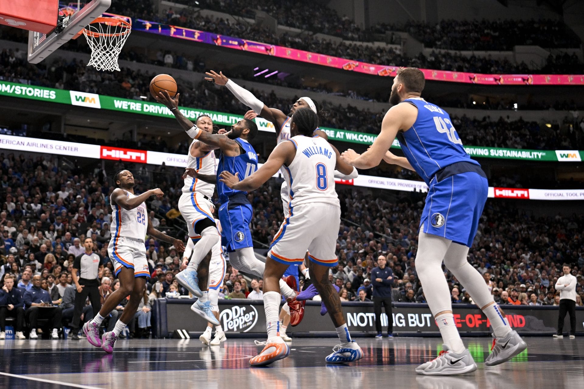 Kyrie Irving intenta anotar entre tres defensores