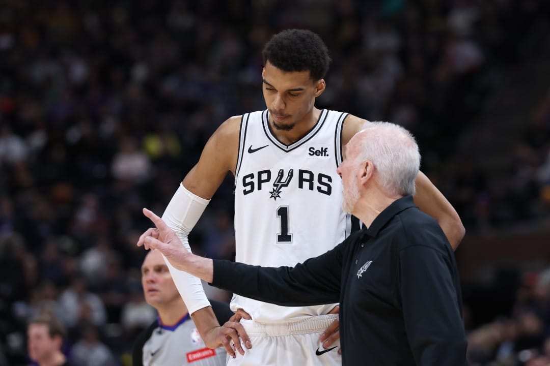 Victor Wembanyama charla con Gregg Popovich