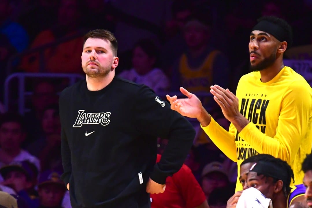 Luka Doncic mira atentamente desde el banquillo.