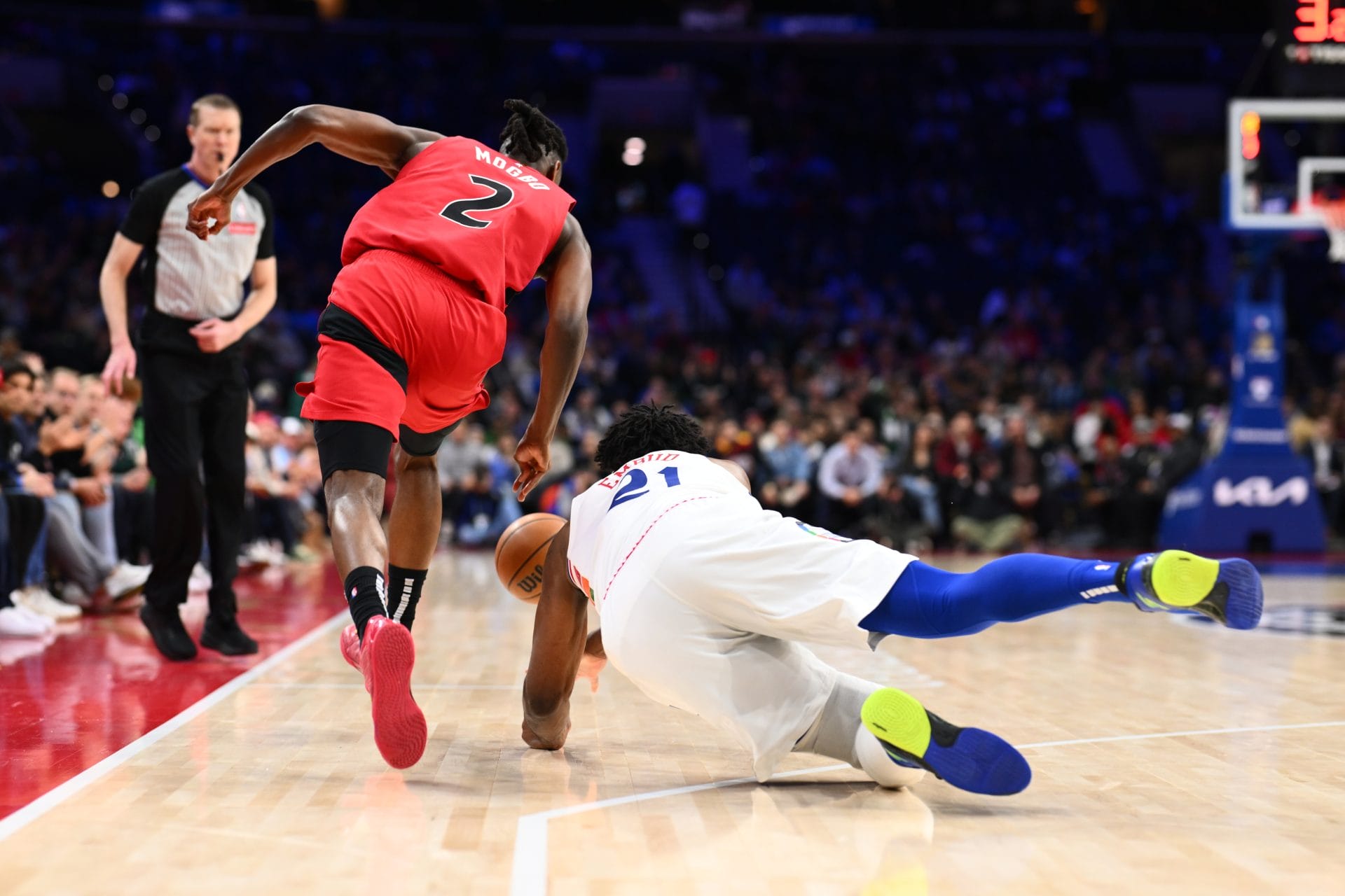 Joel Embiid lucha por un balón ante los Raptors