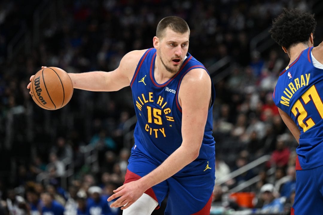 Nikola Jokic pasa un bloqueo de Jamal Murray.