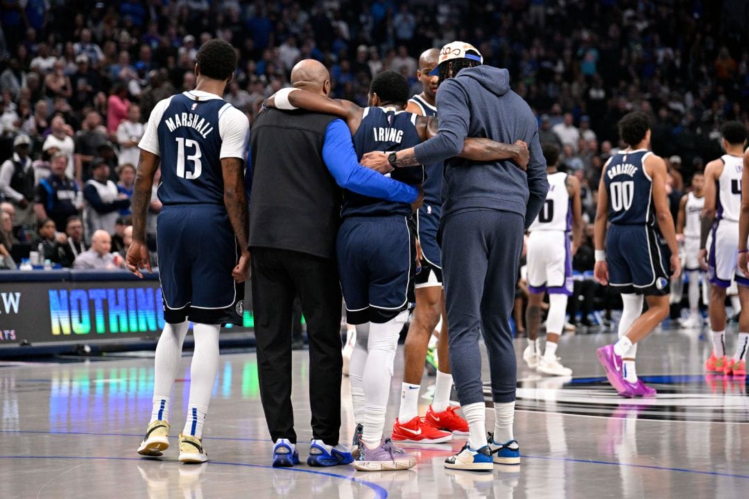 Kyrie Irving se marcha del campo ayudado por compañeros y staff.