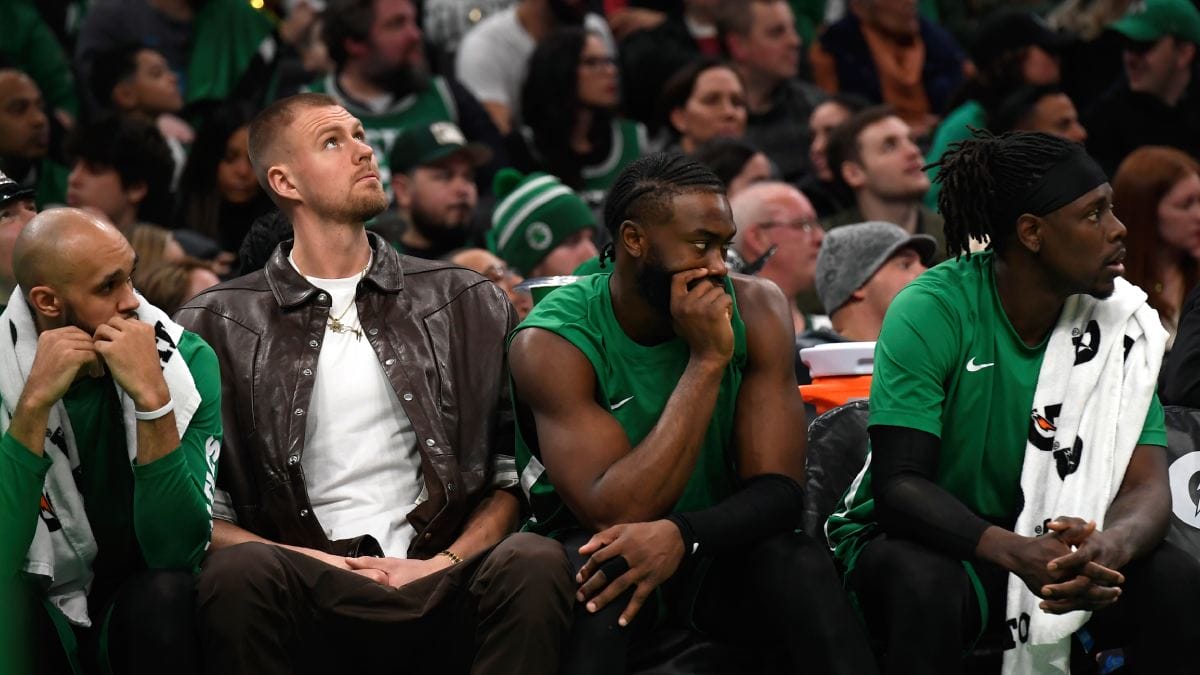 De izquierda a derecha en el banquillo de los Boston Celtics: Derrick White, Kristaps Porzingis, Jaylen Brown y Jrue Holiday.