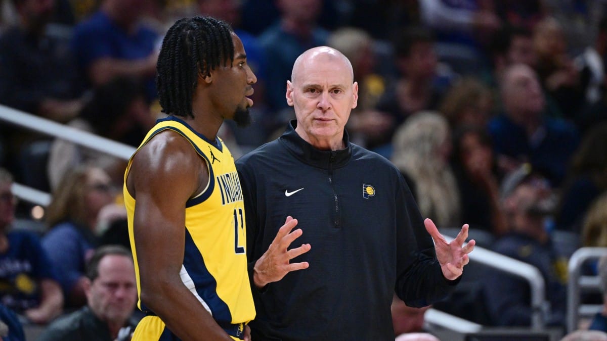 Rick Carlisle conversa con Aaron Nesmith durante un partido de playoffs.
