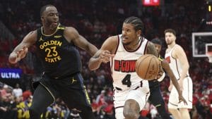 Jalen Green intenta superar a Draymond Green en un partido de playoffs.