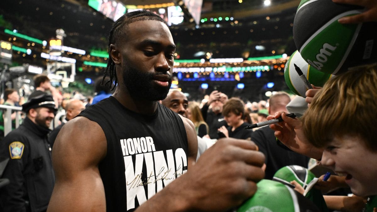 Jaylen Brown firma balones a pie de grada.