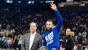 Joe Lacob y Stephen Curry posan ante la afición.