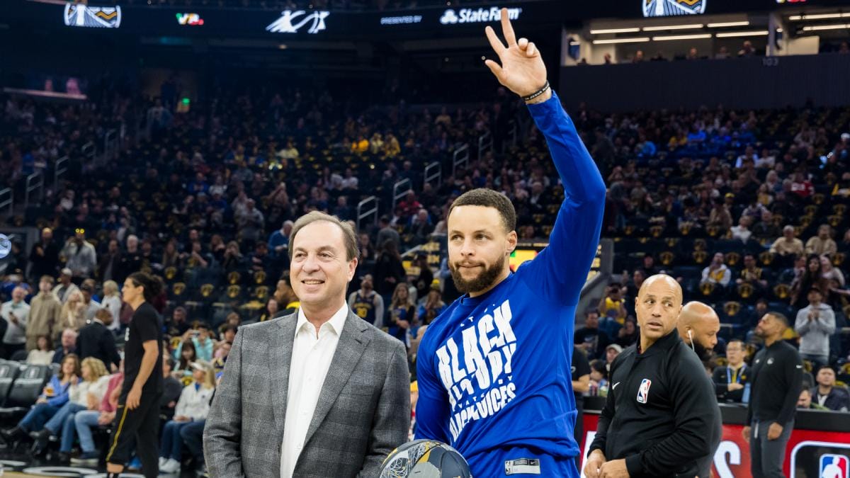 Joe Lacob y Stephen Curry posan ante la afición.