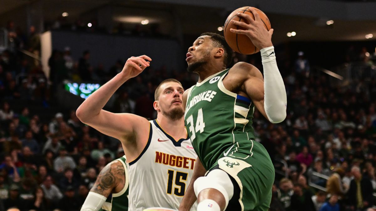 Nikola Jokic y Giannis Antetokounmpo batiéndose bajo el aro.