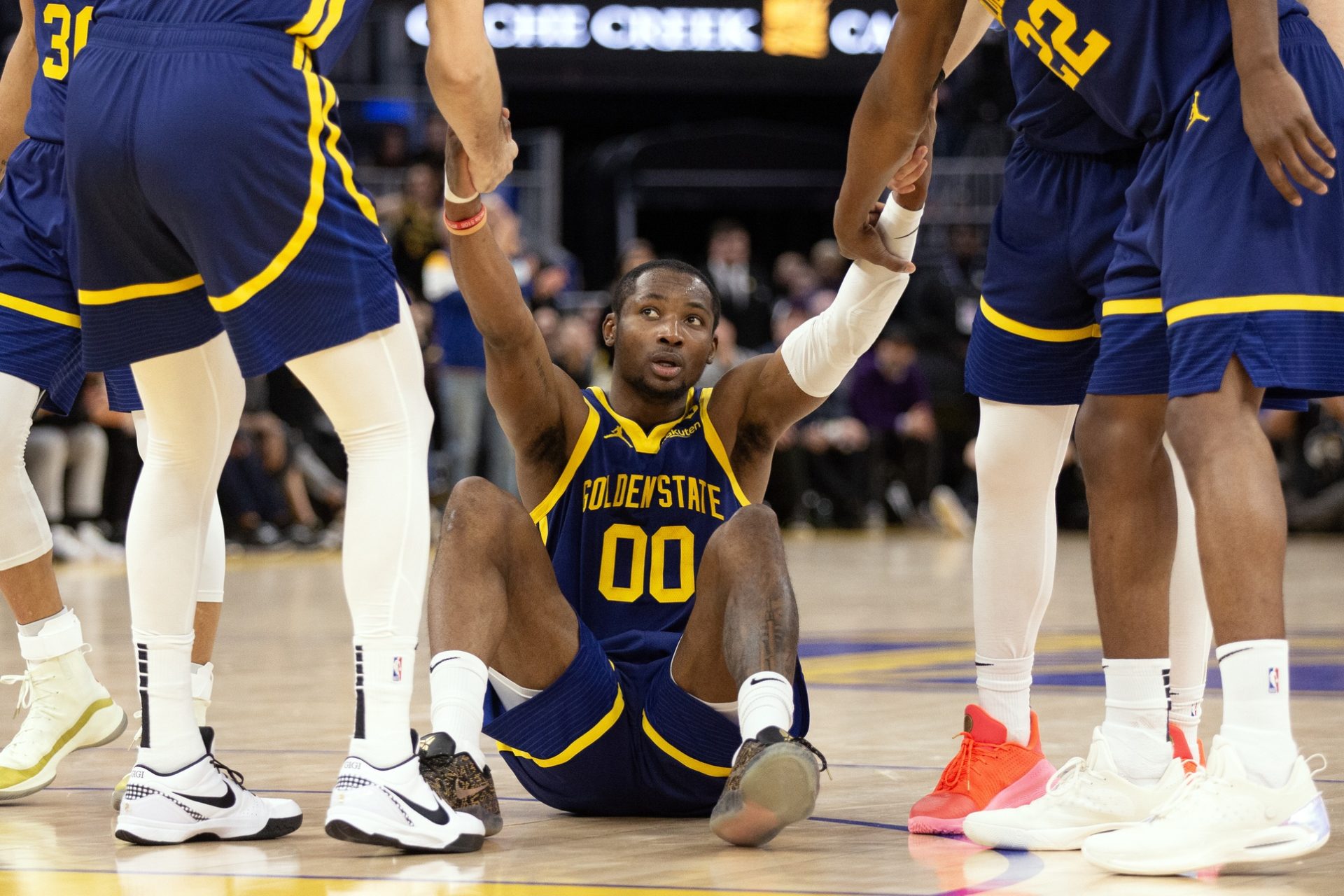 Kuminga-ayudado-por-sus-compañeros-de-los-warriors-a-levantarse