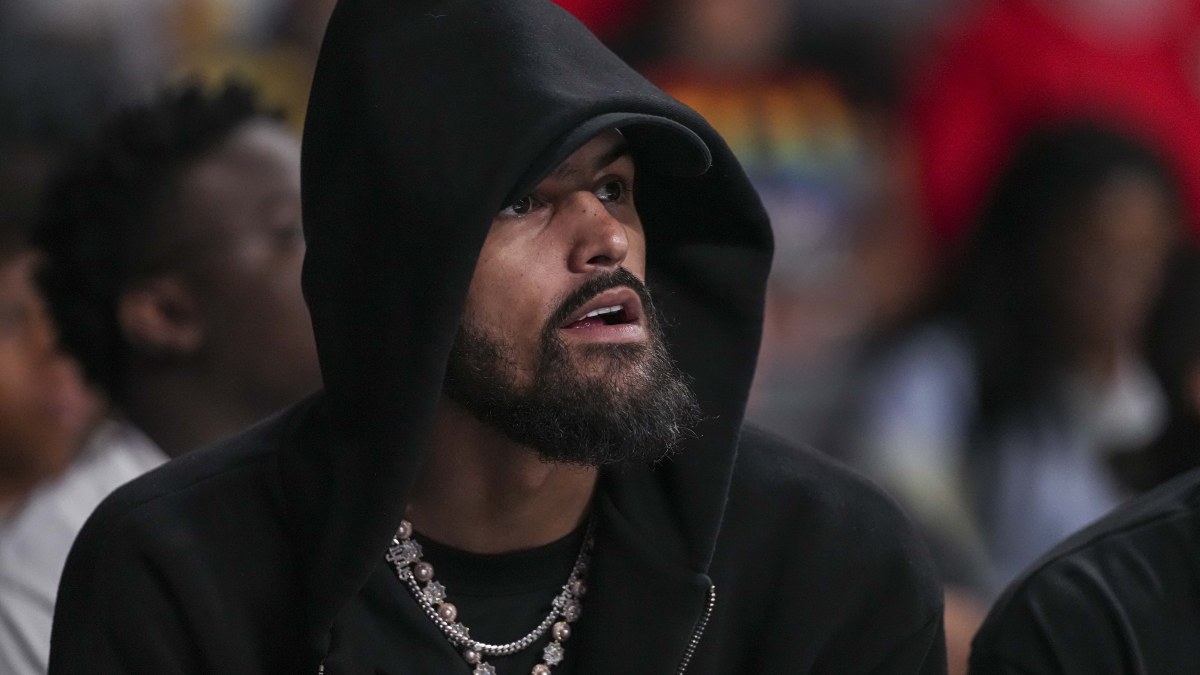 Trae Young, siguiendo un partido de los Atlanta Hawks desde la banda.
