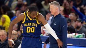 Jonathan Kuminga y Steve Kerr comparten risas en la banda.