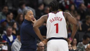James Harden escucha atentamente a su entrenador, Tyronn Lue.