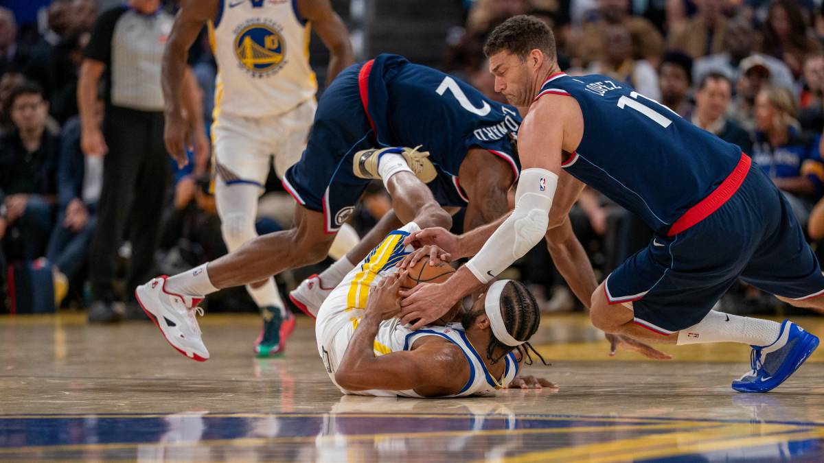 Moses Moody, de los Golden State Warriors, pelea con Brook Lopez por un balón.