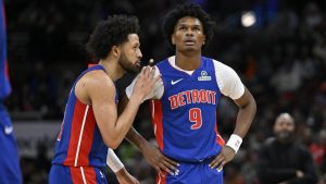 Cade Cunningham conversa con Ausar Thompson durante un partido de los Detroit Pistons.