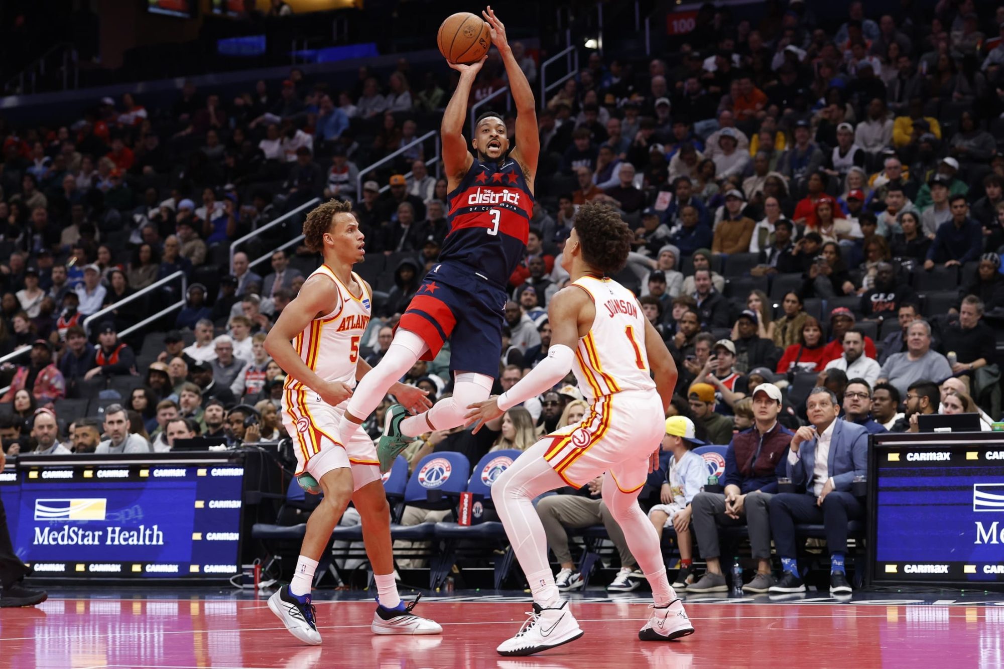 Un-desequilibrado-CJ-McCollum-lanzando-a-canasta-sobre-dos-defensores