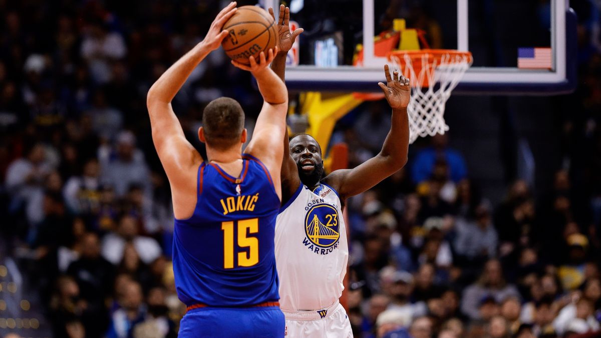 Nikola Jokic lanza a canasta ante la oposición de Draymond Green.