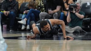 Victor Wembanyama, tumbado en el suelo con gestos de dolor.