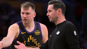 J.J. Redick, conversando con Luka Doncic durante un partido de los Lakers.