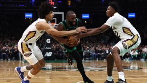 Jaylen Brown trata de zafarse de dos defensores de los Pelicans.