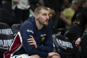 Nikola Jokic, sentado en el banquillo, mirando