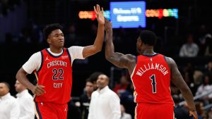Derik Queen y Zion Williamson chocan manos con el uniforme de los New Orleans Pelicans.