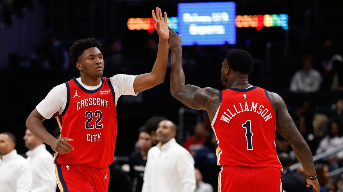Derik Queen y Zion Williamson chocan manos con el uniforme de los New Orleans Pelicans.